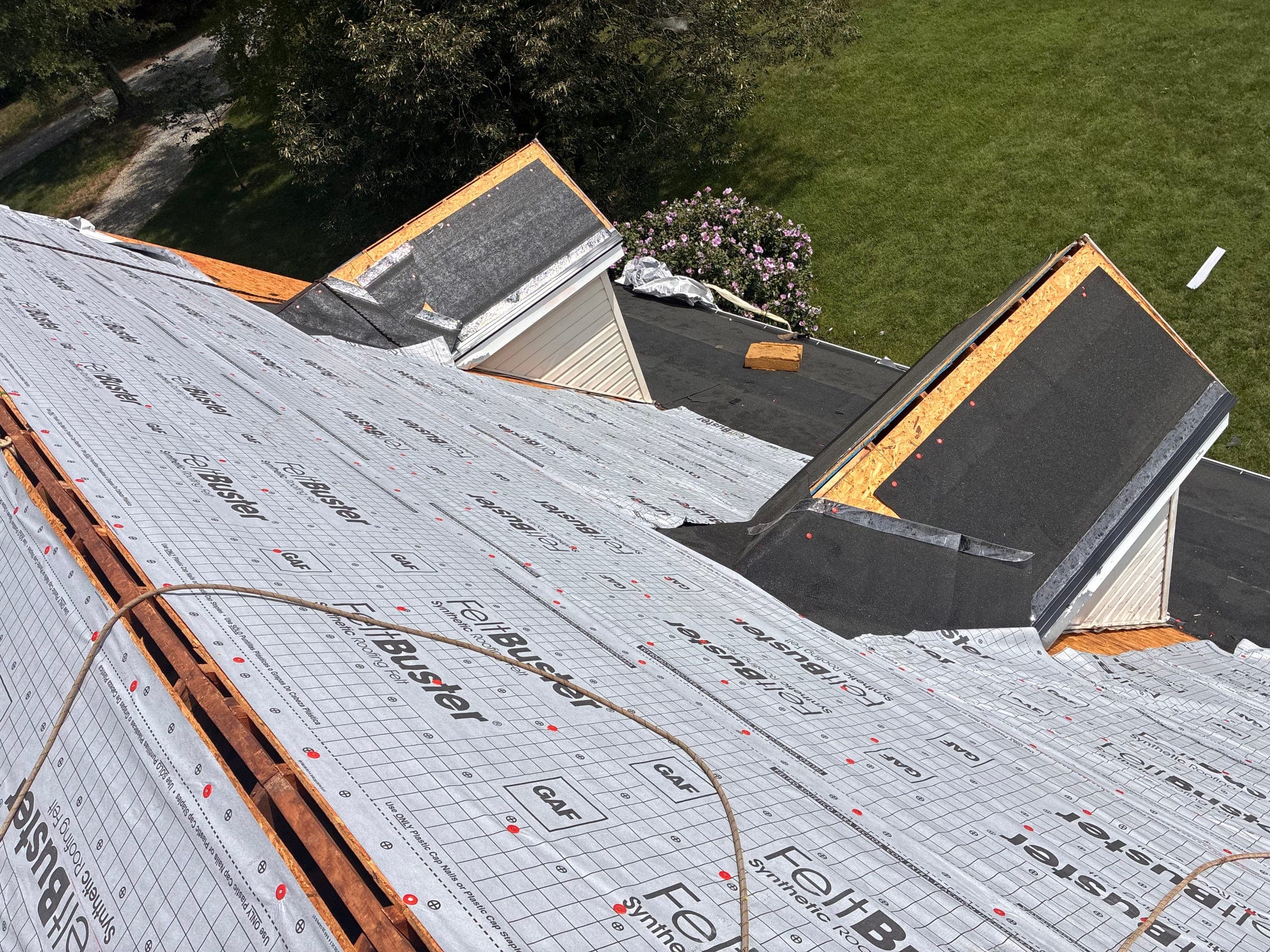 Roof dormers wrapped in synthetic underlayment during a replacement