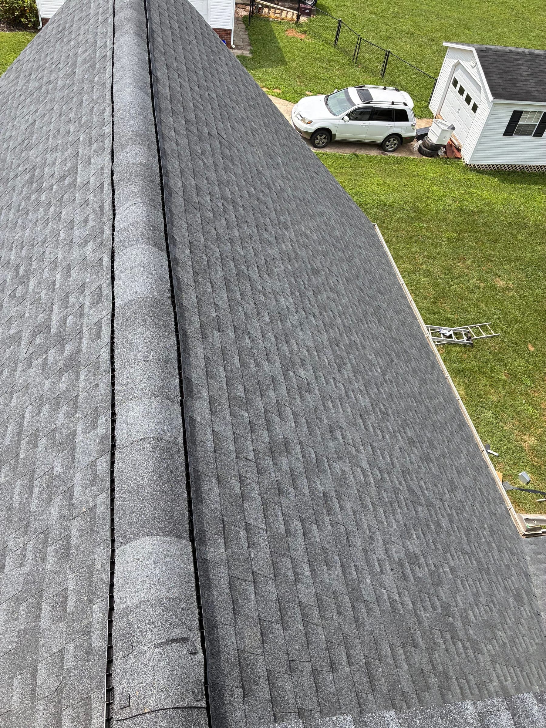 The same roof ridge finished in gray architectural shingles